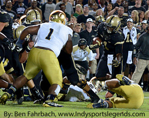 Purdue coach Darrell Hazell watches as Akeem Hunt (1 in black) tries to avoid Notre Dame's Louis Nix III (No. 1 in white).