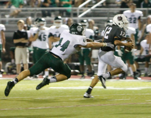 Lawrence Central quarterback Tyler Redfern tries to avoid the rush. Photo by Justin Whitaker.