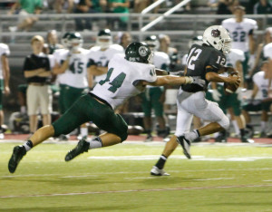 Lawrence Central quarterback Tyler Redfern (12), shown here against Louisville Trinity, struggled against Center Grove. Photo by Justin Whitaker.