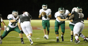 Lawrence Central's defensive line rushes Louisville Trinity quarterback Reggie Bonnafon. Photo by Jistin Whitaker.