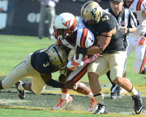 Purdue's Leroy Clark (3) and Andy James Garcia (42) take down Virginia Tech's Isaiah Ford. Photo by Ben Fahrbach.